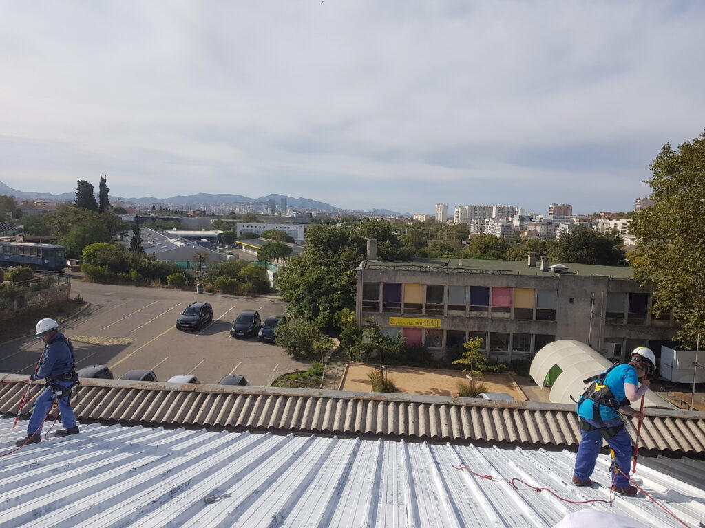 Appliquer du CoolRoof sur de la tôle : c'est une des compétences que les participantes et participants ont acquéries pendant le chantier.